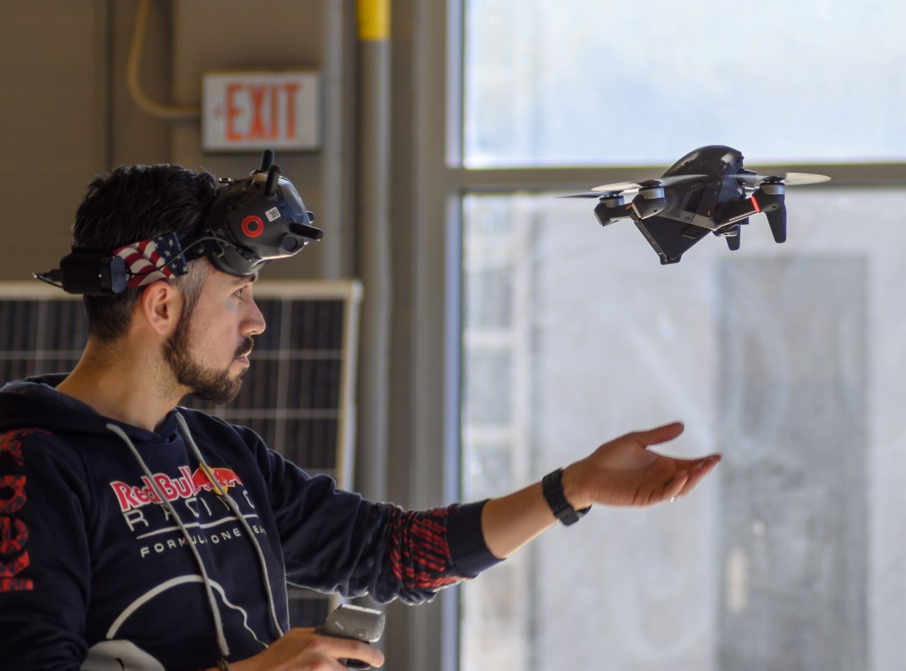 A man flying a drone in a drone lab